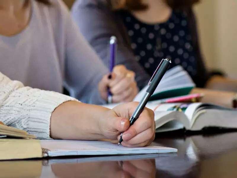 close up of a student writing in a notebook 