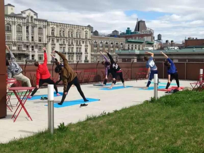 Several students doing yoga on a green roof